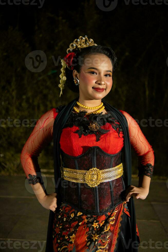 an Indonesian dancer posing with her beautiful and beautiful hands while wearing makeup at night photo