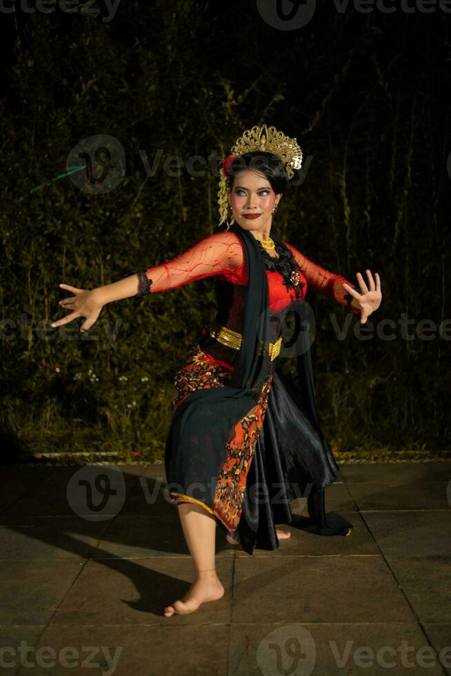 un javanés bailarín bailando con oro accesorios y un cara lleno de maquillaje foto