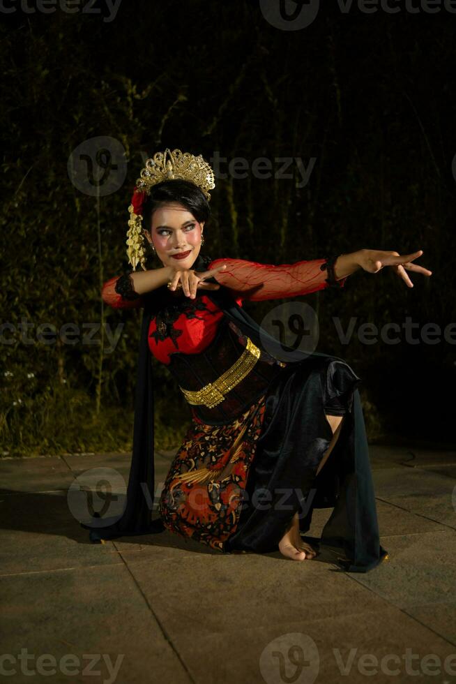 un javanés bailarín bailando con oro accesorios y un cara lleno de maquillaje foto