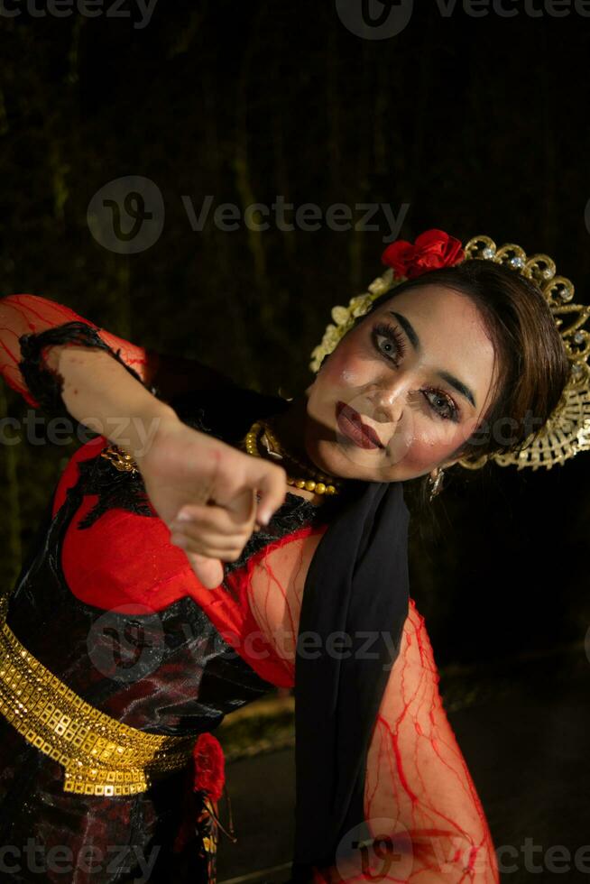 a Javanese dancer dances in front of the audience with an agile body in a black costume photo