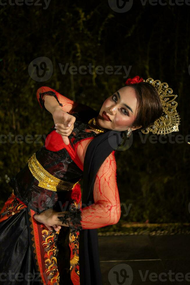 a Javanese dancer dances in front of the audience with an agile body in a black costume photo