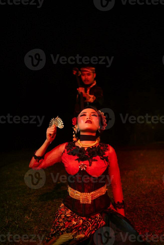 a female dancer in a red costume sat in the silence of the night which strengthened the sadness photo