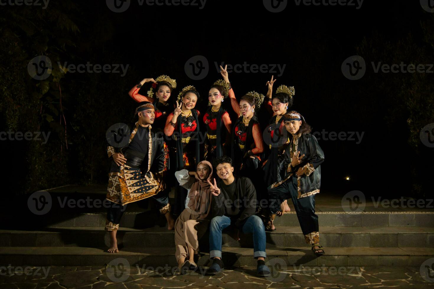 a group of Indonesian dancers with happy facial expressions and looking unified when wearing red costumes that look stunning photo