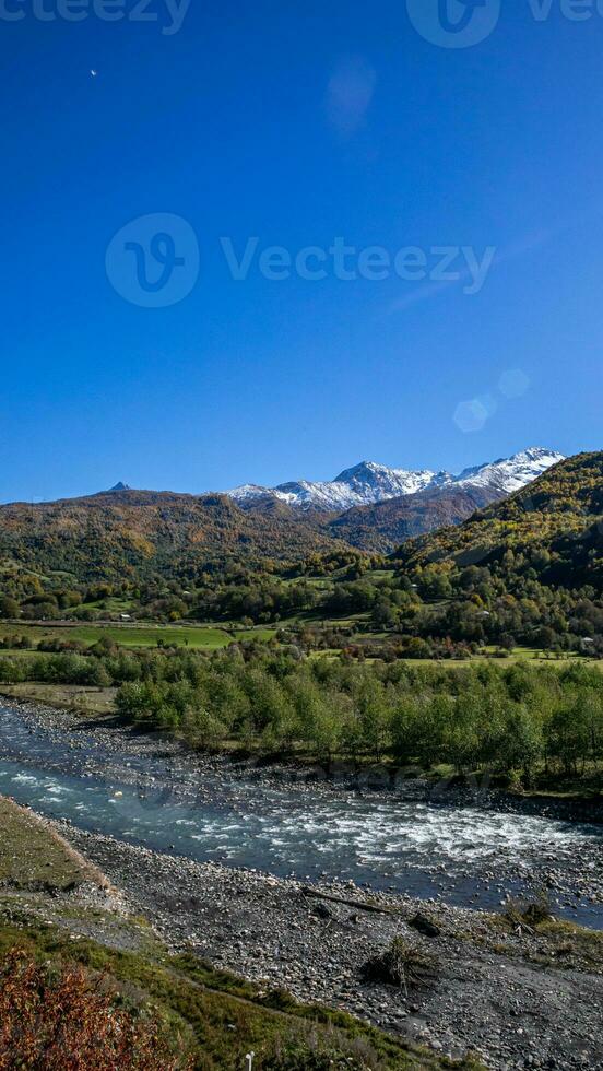 AI generated Autumn Serenity River Flow with Snowy Peaks photo
