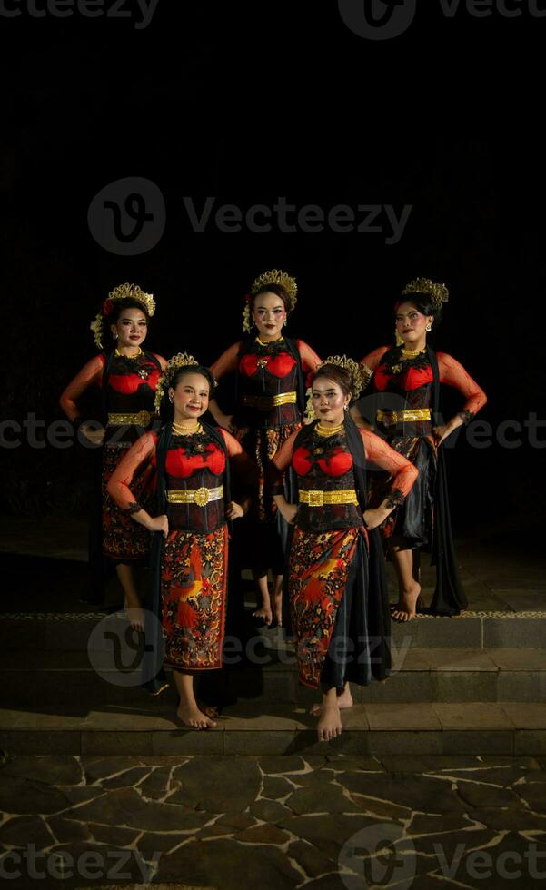 a group of dancers stand and unite in red costumes that show unity photo