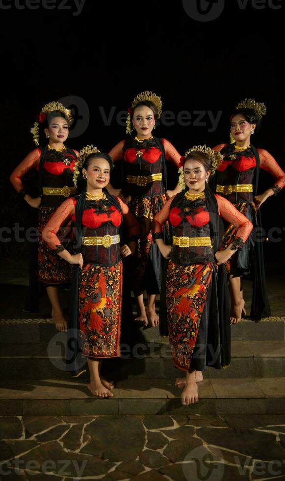 a group of dancers stand and unite in red costumes that show unity photo