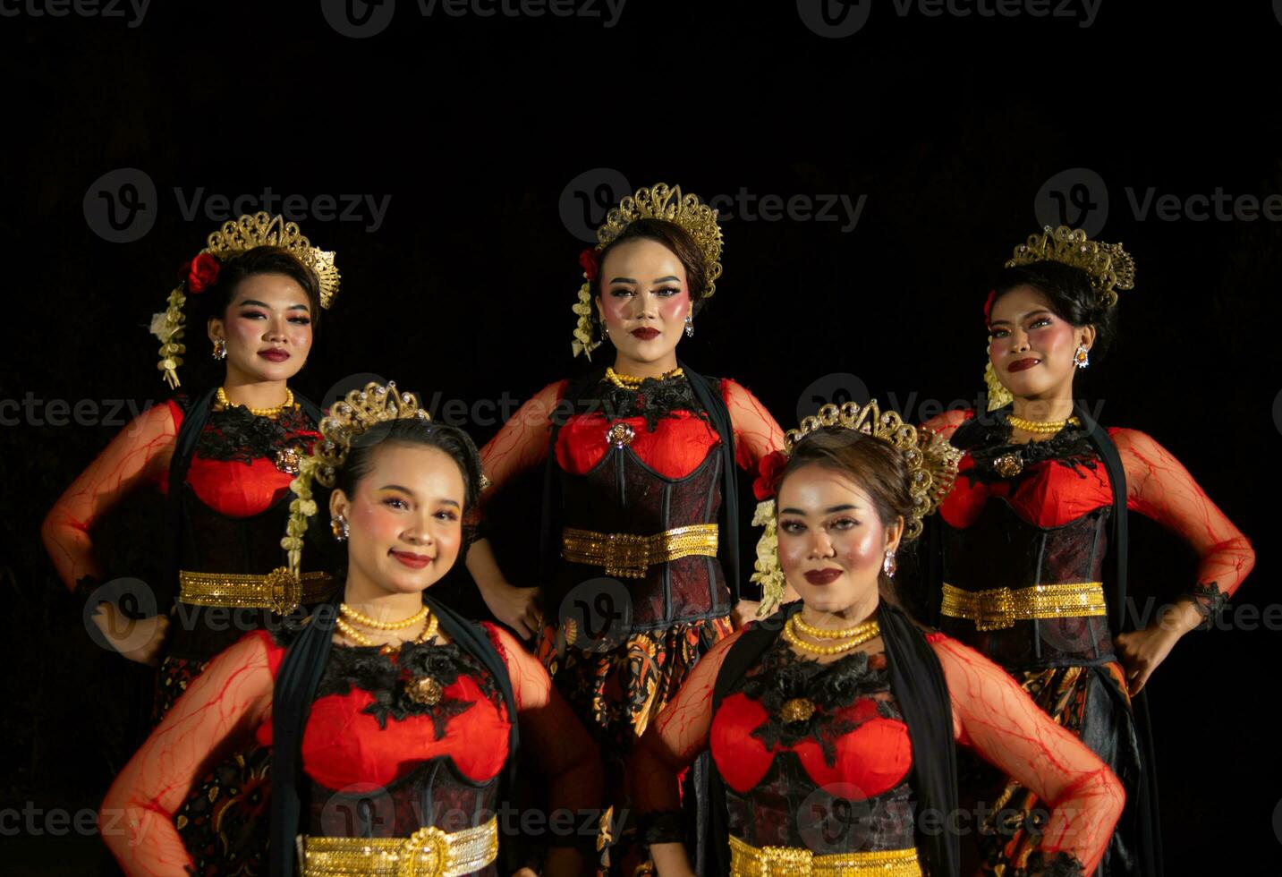 un grupo de bailarines estar alto como rojo disfraces proporcionar un dramático y agraciado contraste foto