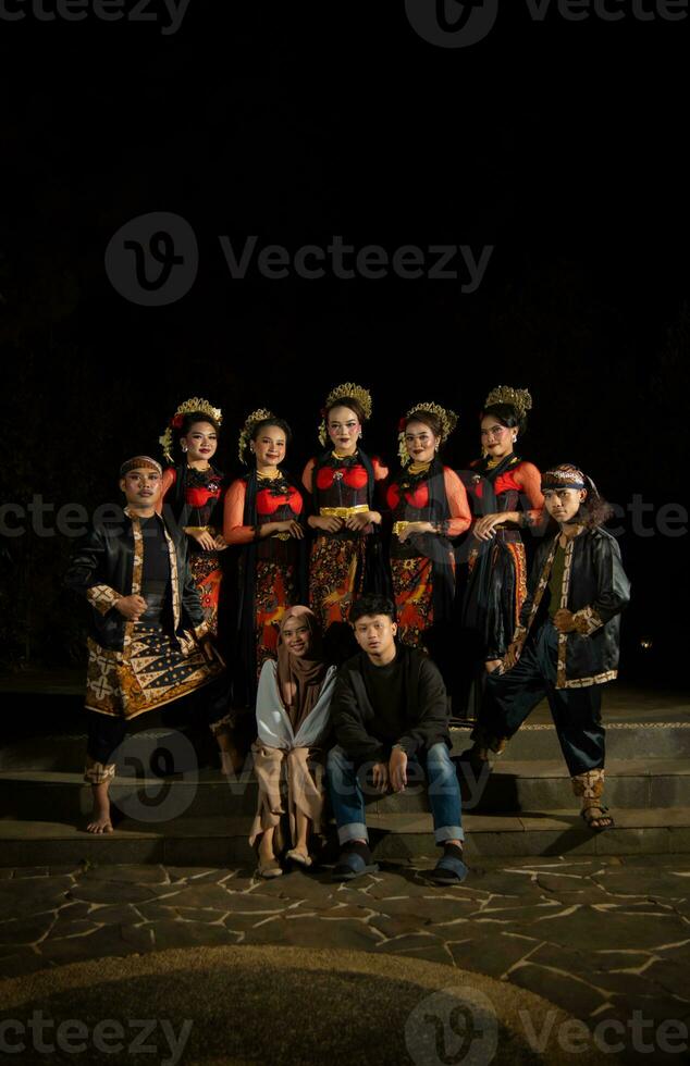 a group of dancers stand tall as red costumes provide a dramatic and graceful contrast photo