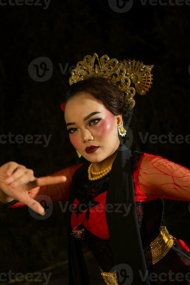 a Balinese woman wears heavy makeup with rosy red lips and sharp hair when posing photo