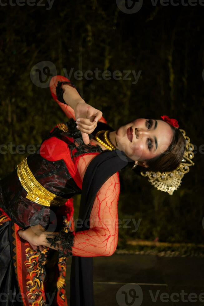 a Javanese dancer dances in front of the audience with an agile body in a black costume photo