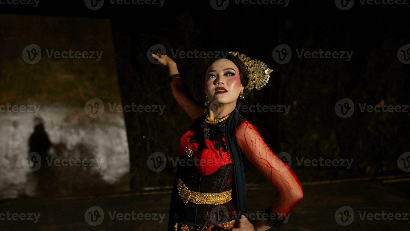 an Indonesian dancer with facial expressions that radiate beauty and happiness dances and captivates the audience photo