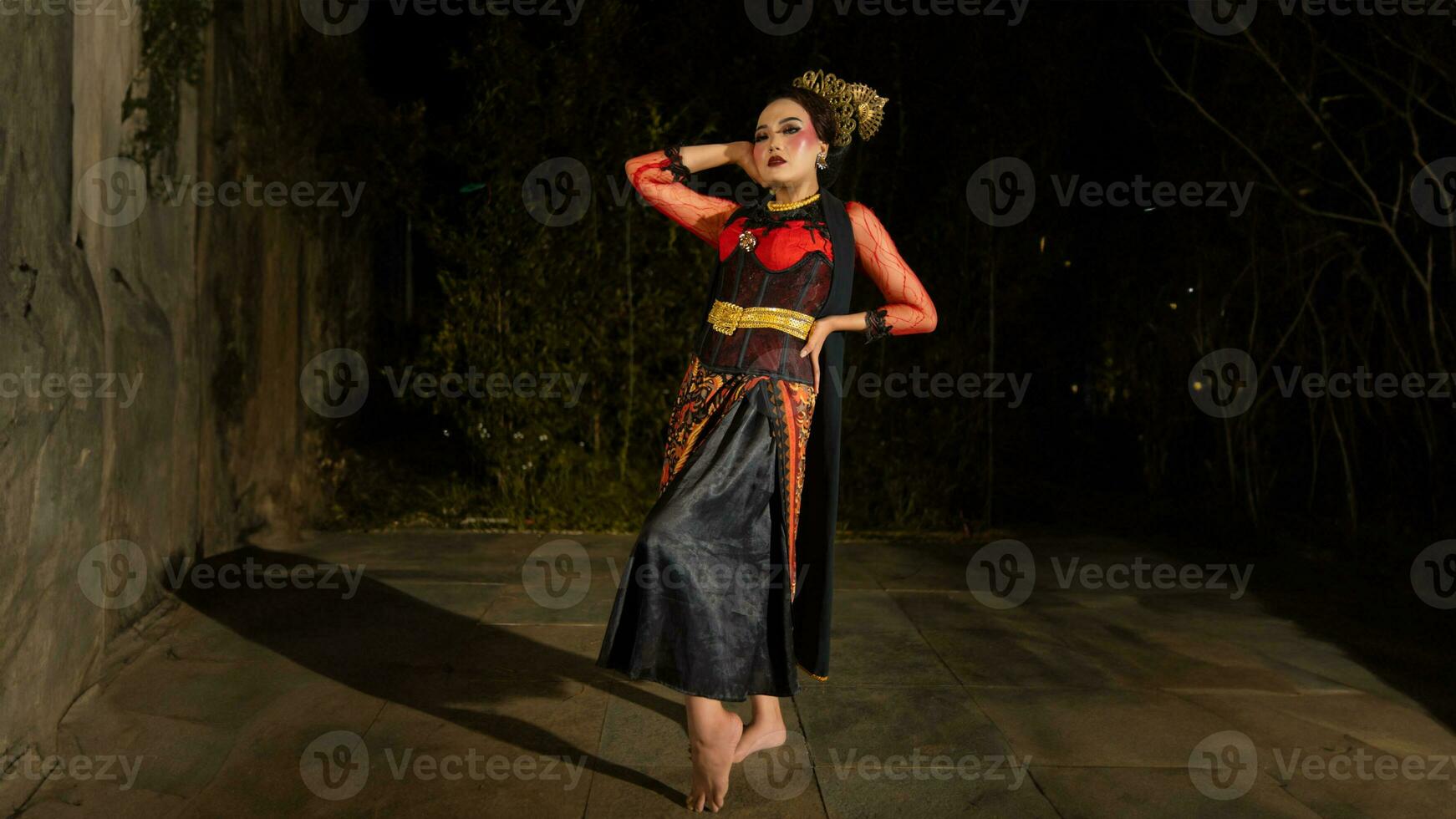 an Asian dancer poses very beautifully while standing in the castle photo