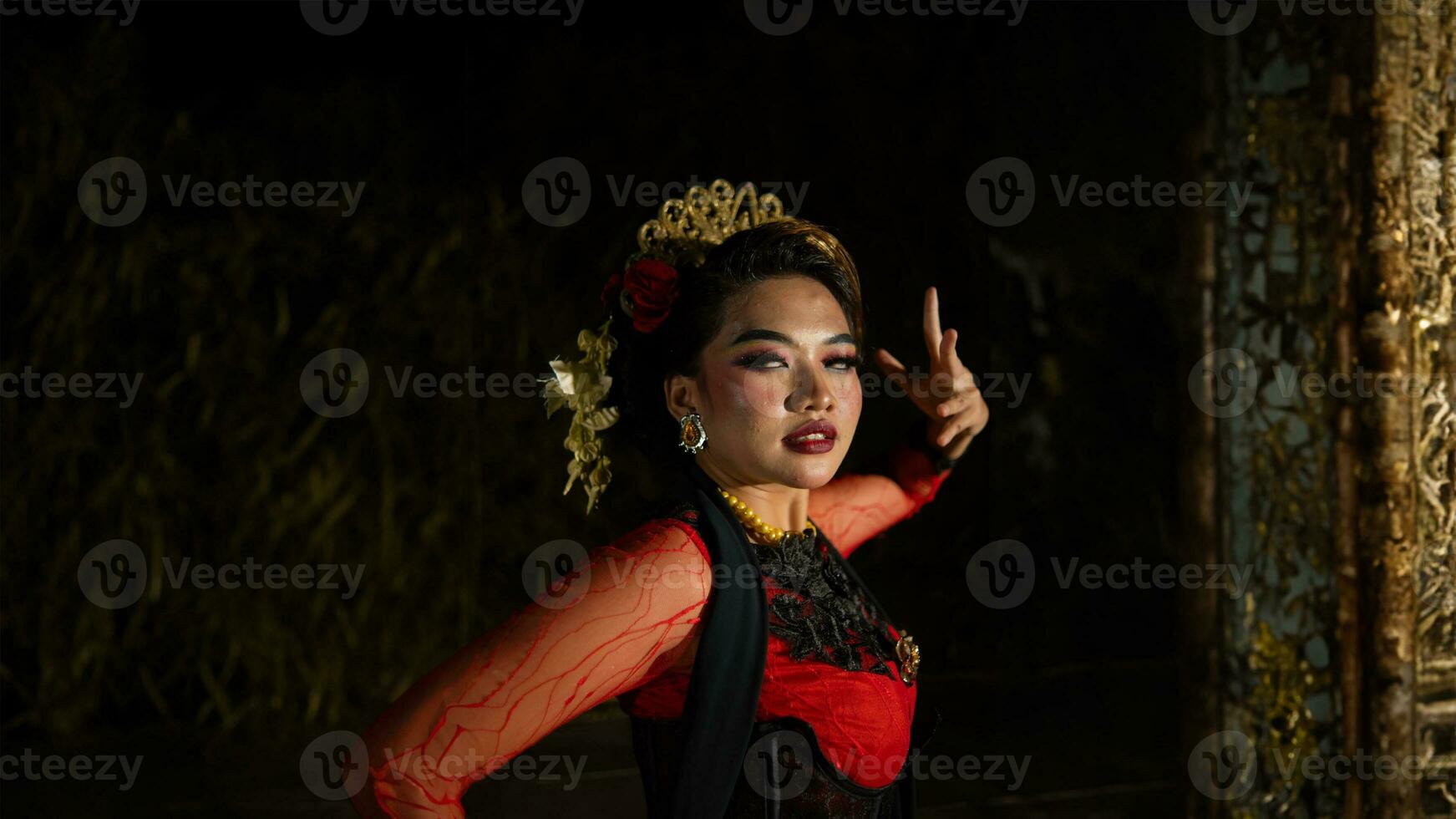 an Asian dancer dancing in front of the yard in a red costume photo