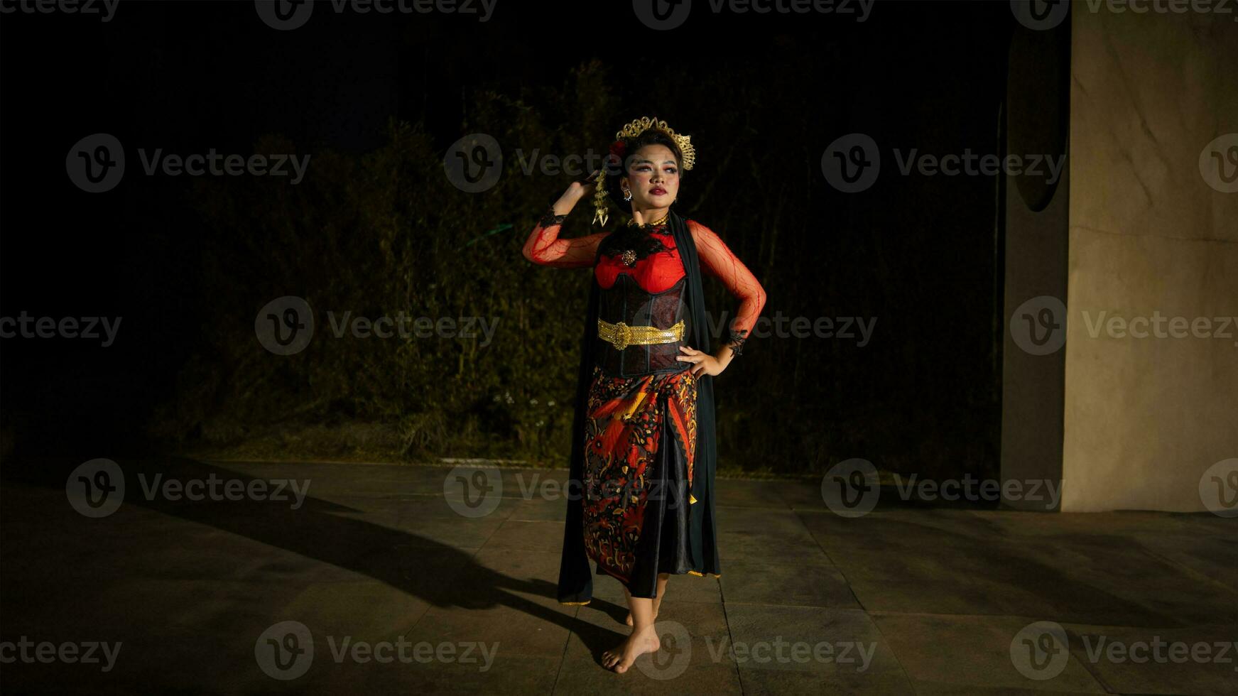 an Indonesian dancer wearing jewelry that shines under the spotlight of the stage lights adds to the brilliance of the performance photo