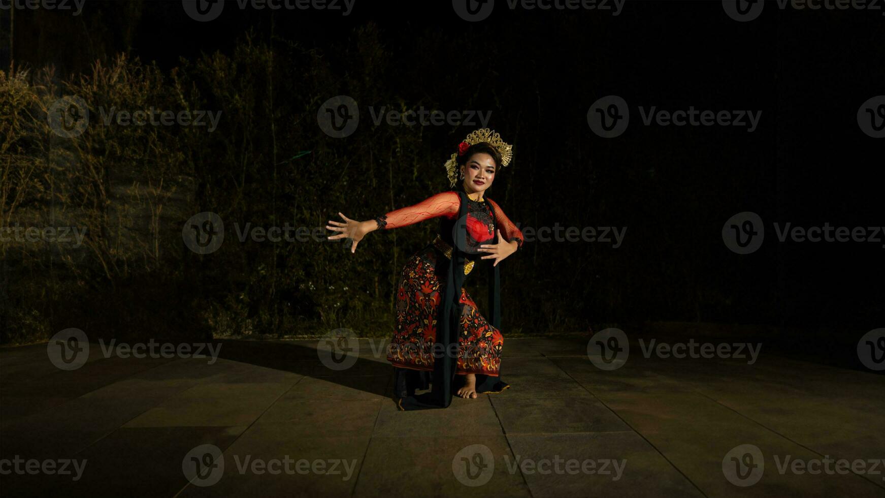 un asiático bailarín bailando en frente de el yarda en un rojo disfraz foto