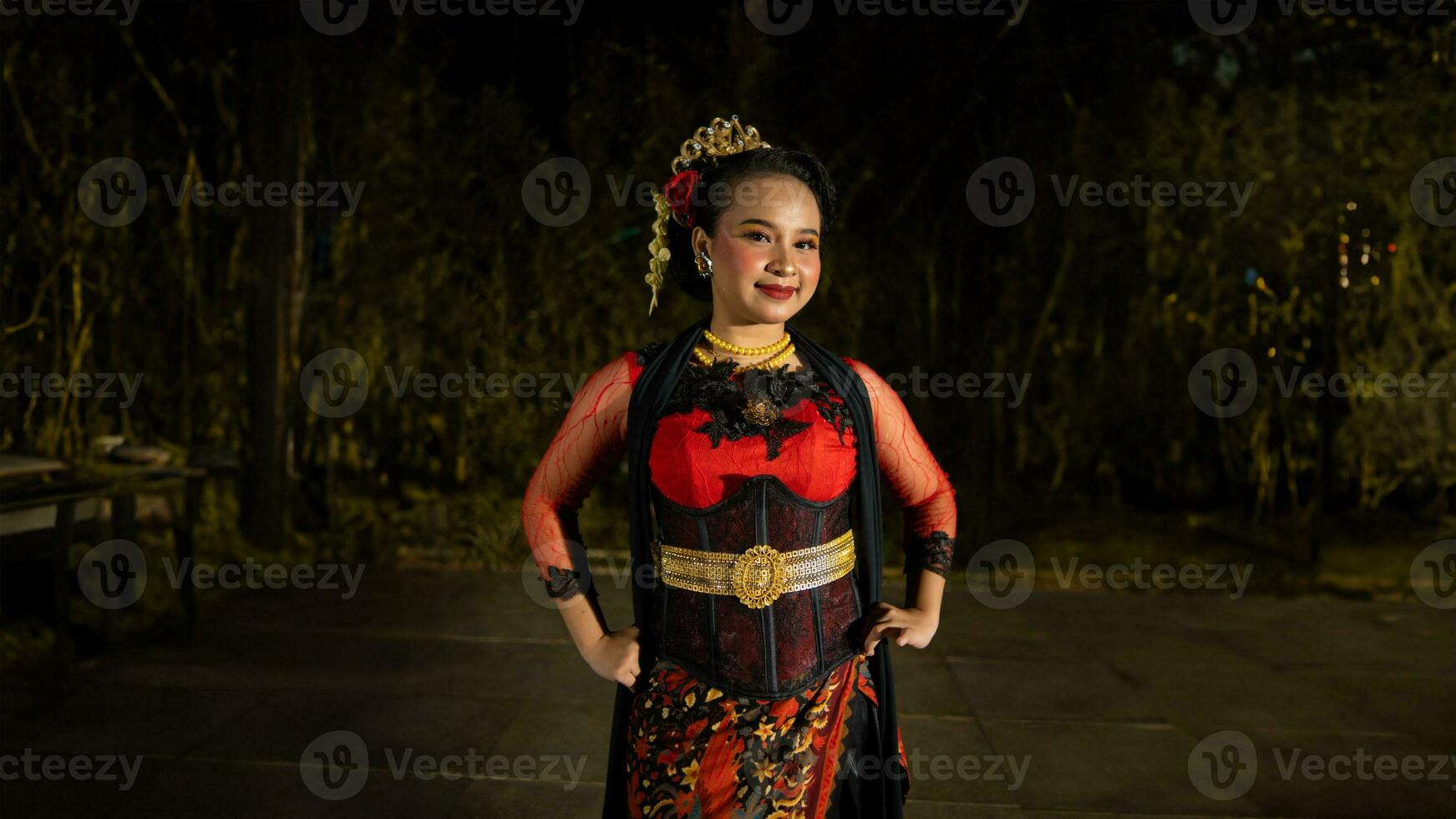 an Indonesian dancer radiates charm that attracts the attention of the audience throughout the performance with her red dress photo