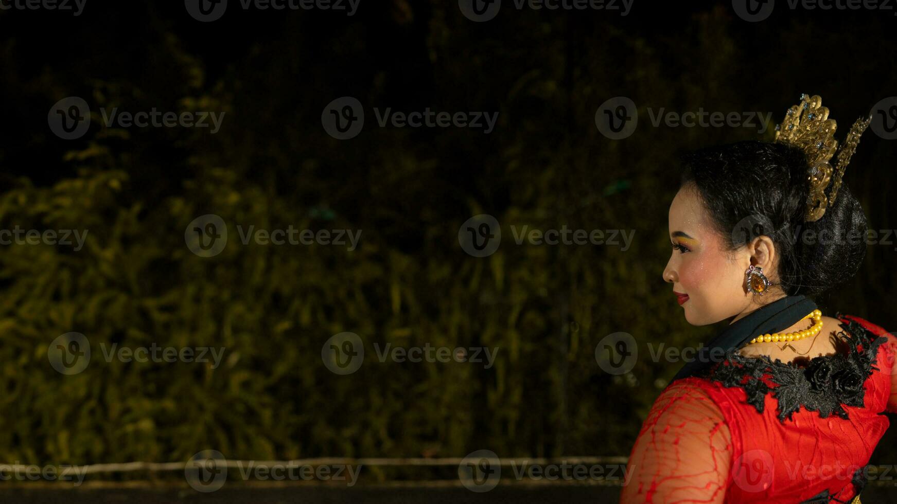 an Indonesian dancer radiates charm that attracts the attention of the audience throughout the performance with her red dress photo