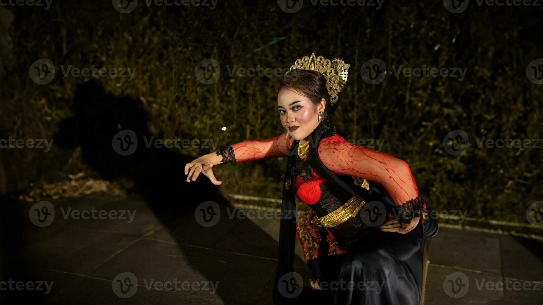 a Javanese dancer makes flexible and flowing movements in time with the rhythm of the music photo