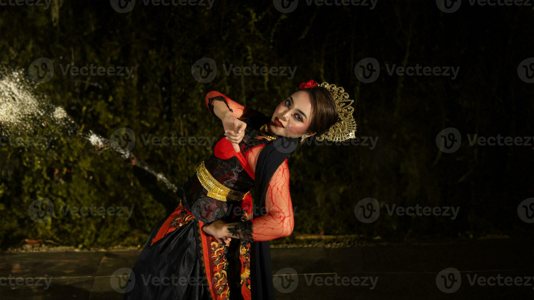 un javanés bailarín en un rojo disfraz presentado un danza ese cautivado el audiencia con su habilidad foto