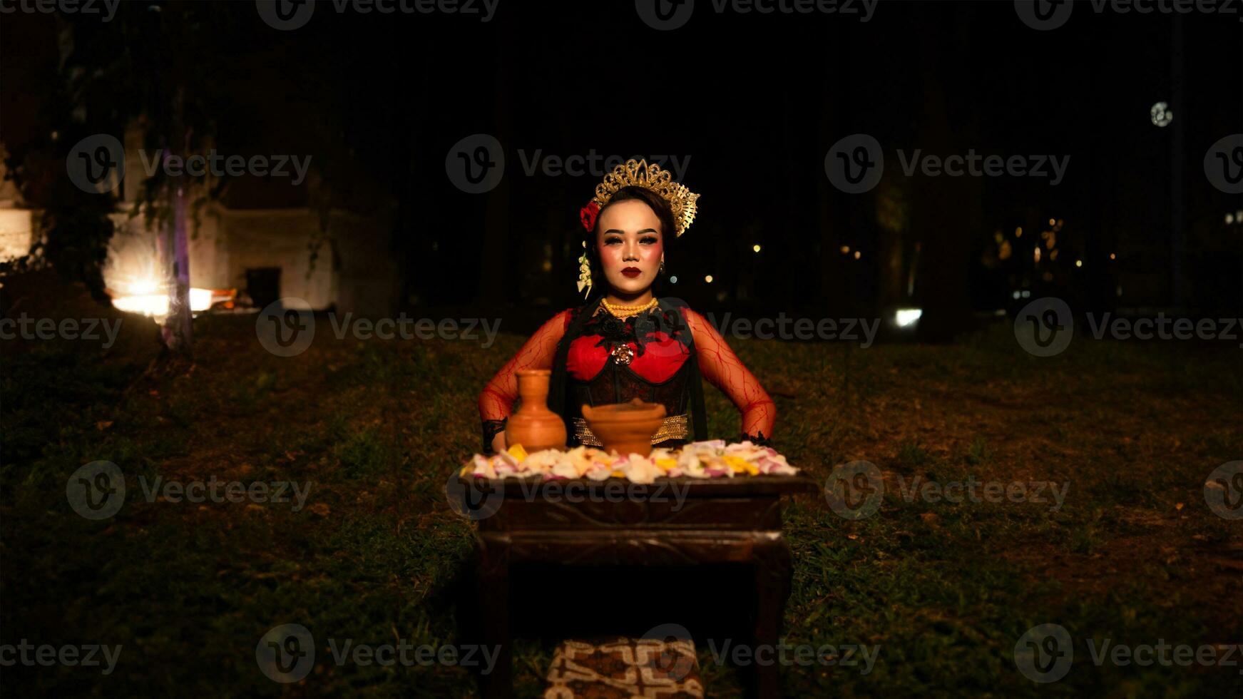 un hembra bailarín quien mira hermosa en un rojo disfraz realiza un ritual ese irradia un aura de belleza y pureza foto