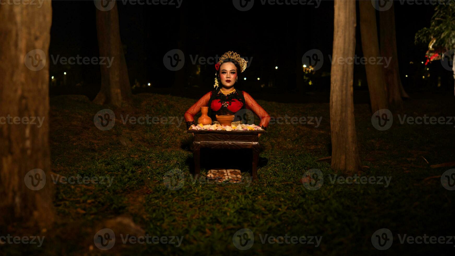 a female dancer who looks beautiful in a red costume performs a ritual that radiates an aura of beauty and purity photo