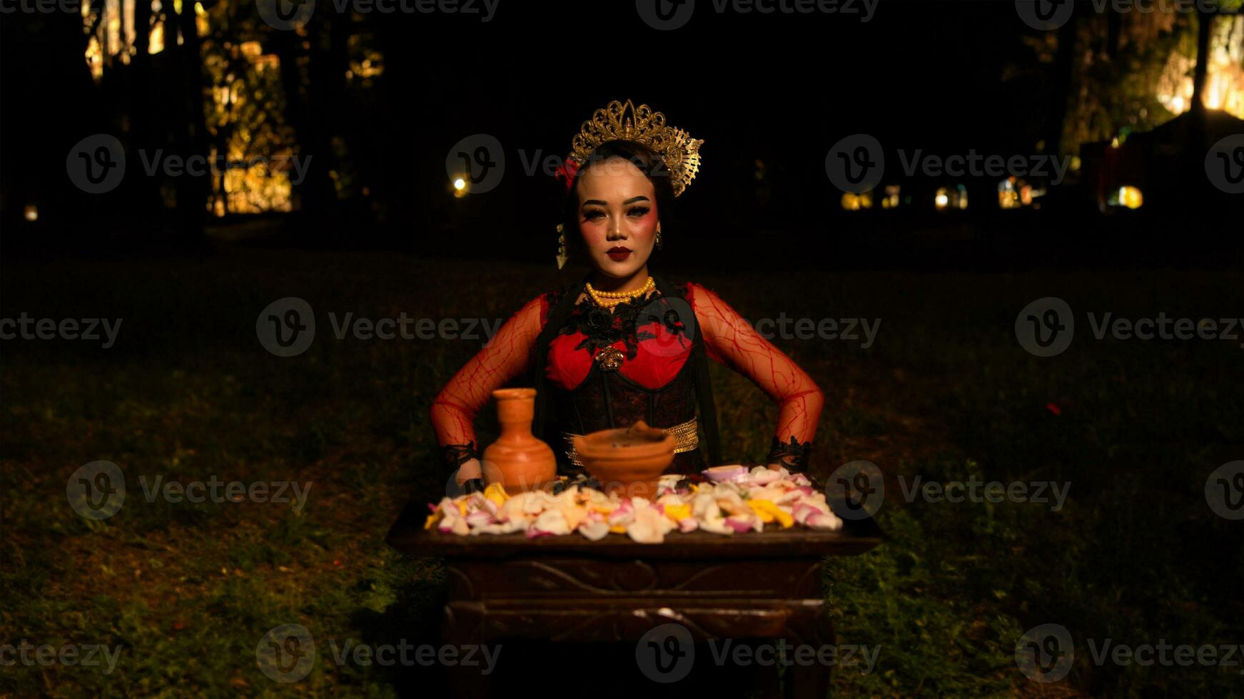 un hembra bailarín mira enfocado en su ritual con un pacífico facial expresión en frente de ofrendas ese Mira Fresco y animado foto