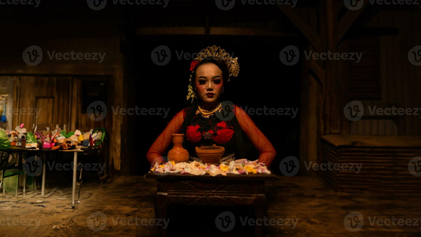 a female dancer sits gracefully and begins her ritual in front of beautiful offerings photo