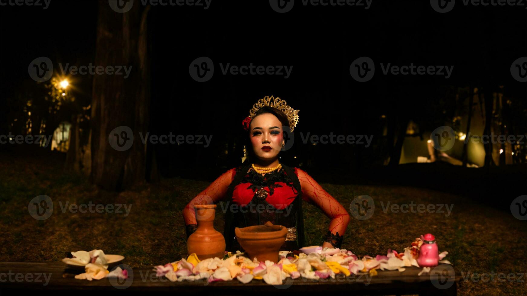 un hembra bailarín realiza un ritual ese crea un mágico y místico atmósfera en frente de flor ofrendas foto