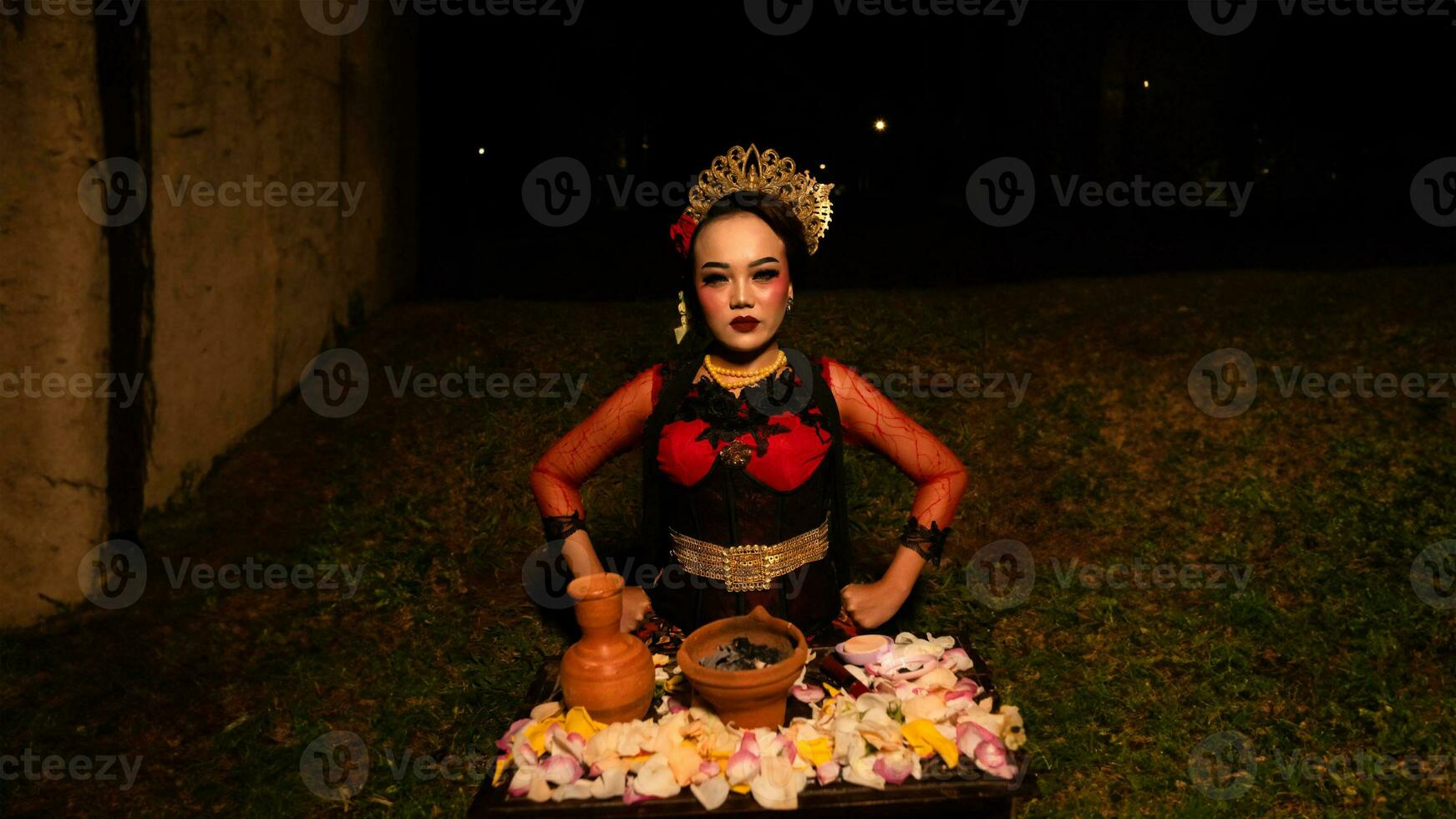 un hembra bailarín realiza un ritual ese crea un mágico y místico atmósfera en frente de flor ofrendas foto