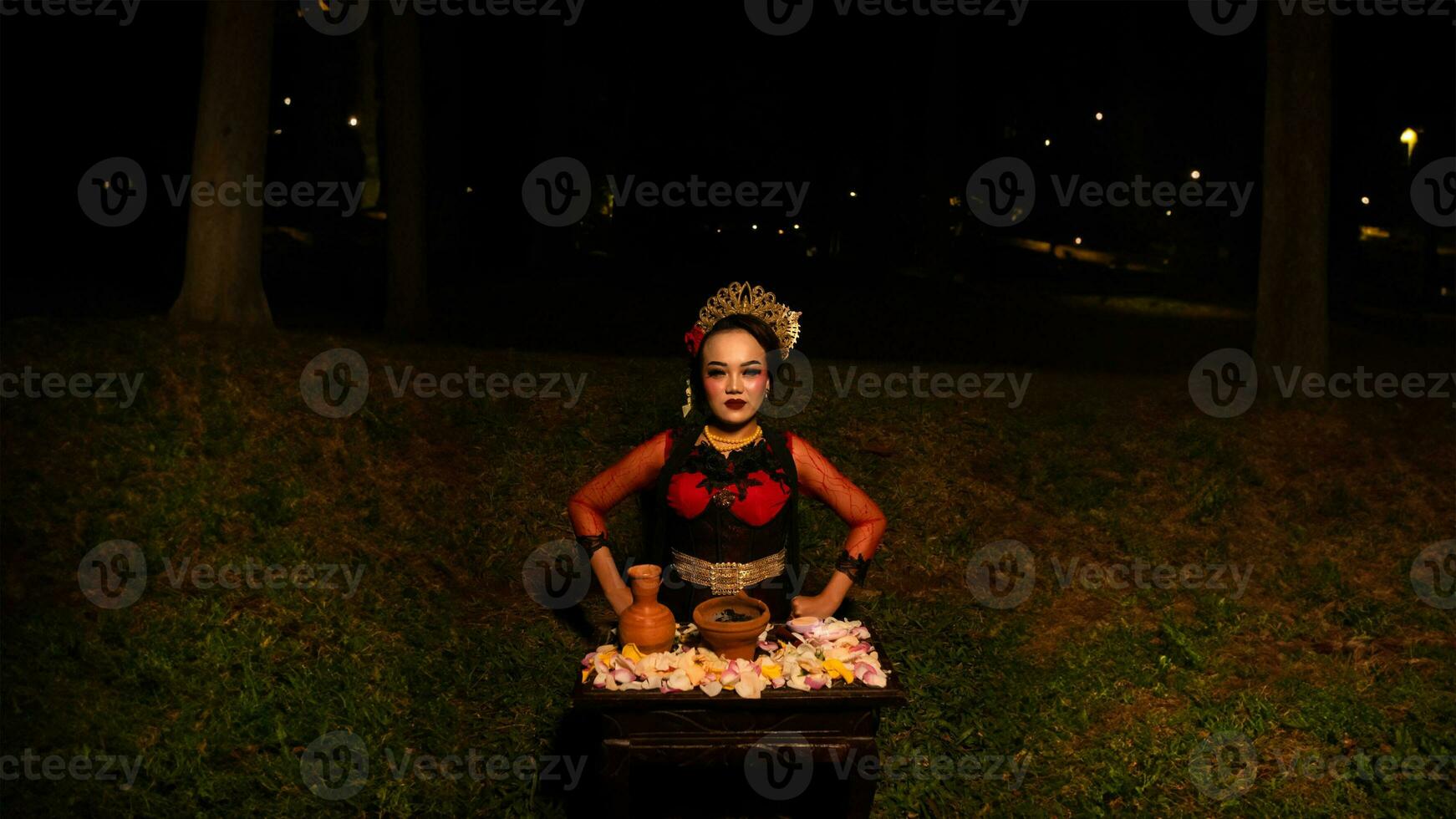 un hembra bailarín realiza un ritual ese crea un mágico y místico atmósfera en frente de flor ofrendas foto