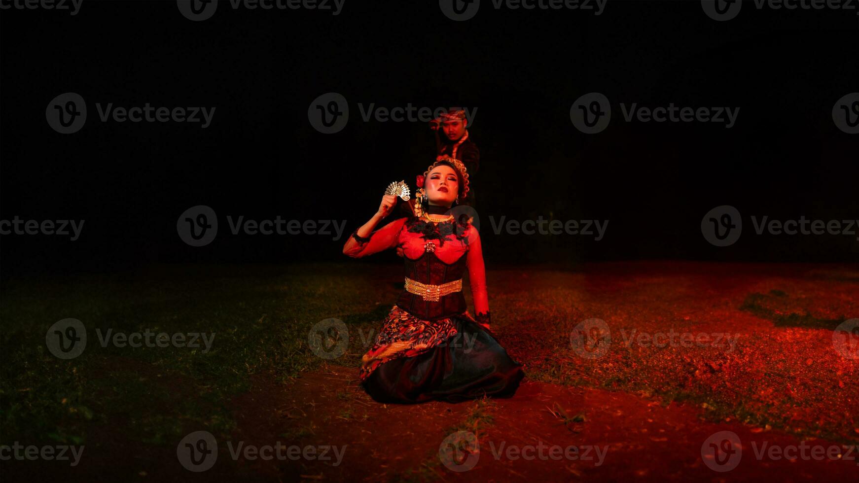 a group of female dancers with faces full of sadness sitting alone in the middle of a field photo