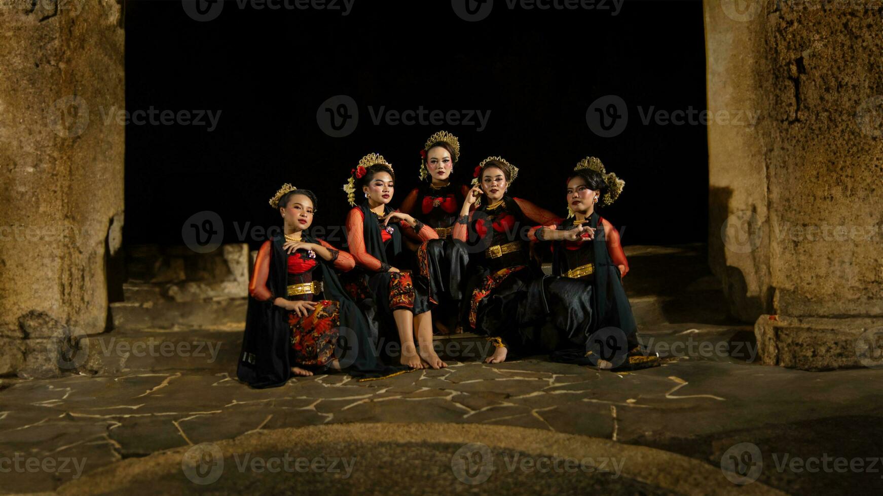 un grupo de bailarines atraer atención en sorprendentes rojo disfraces y sentar juntos foto