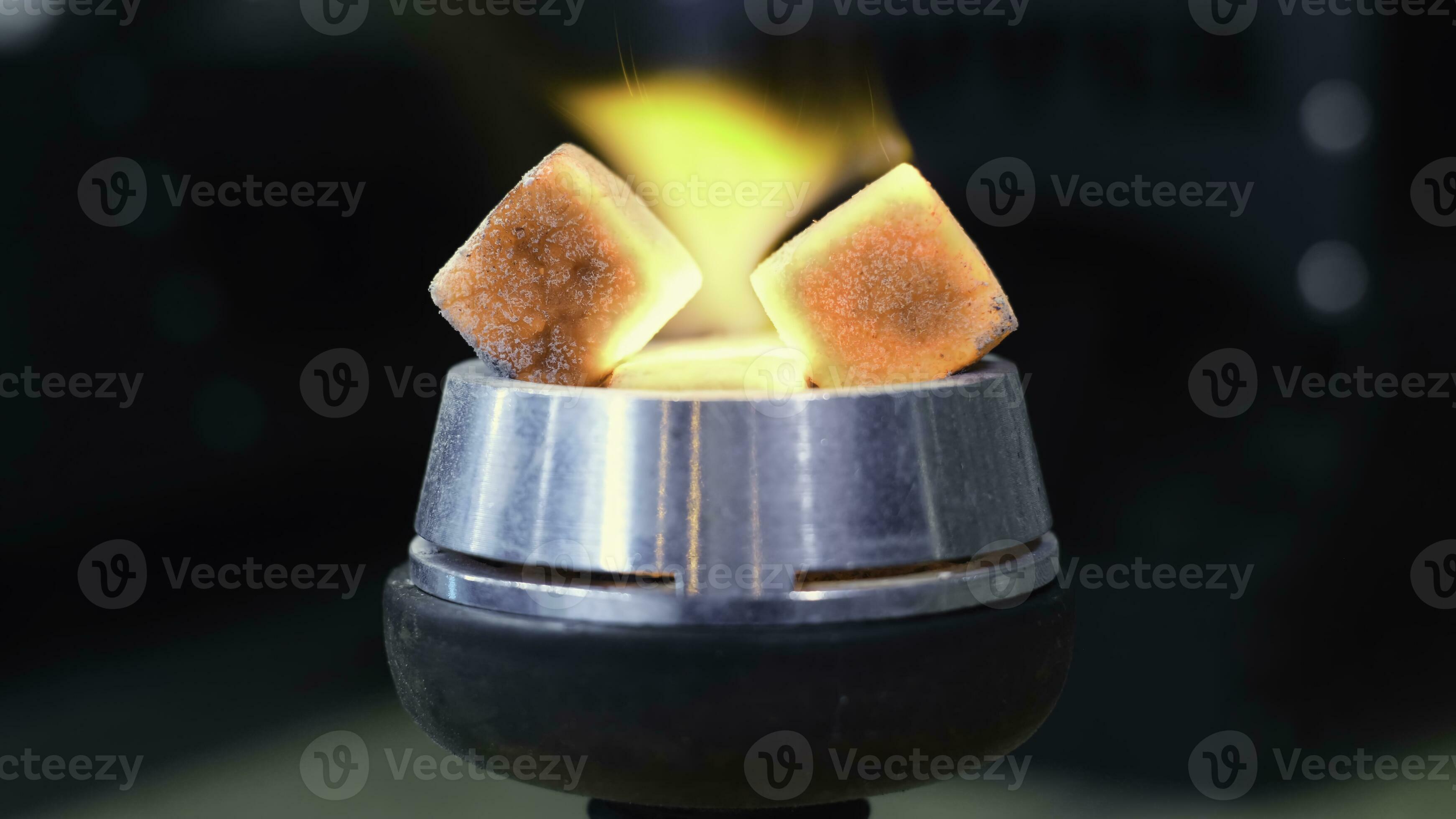 Closeup of burning embers on hookah. Media. Square red coals ignite