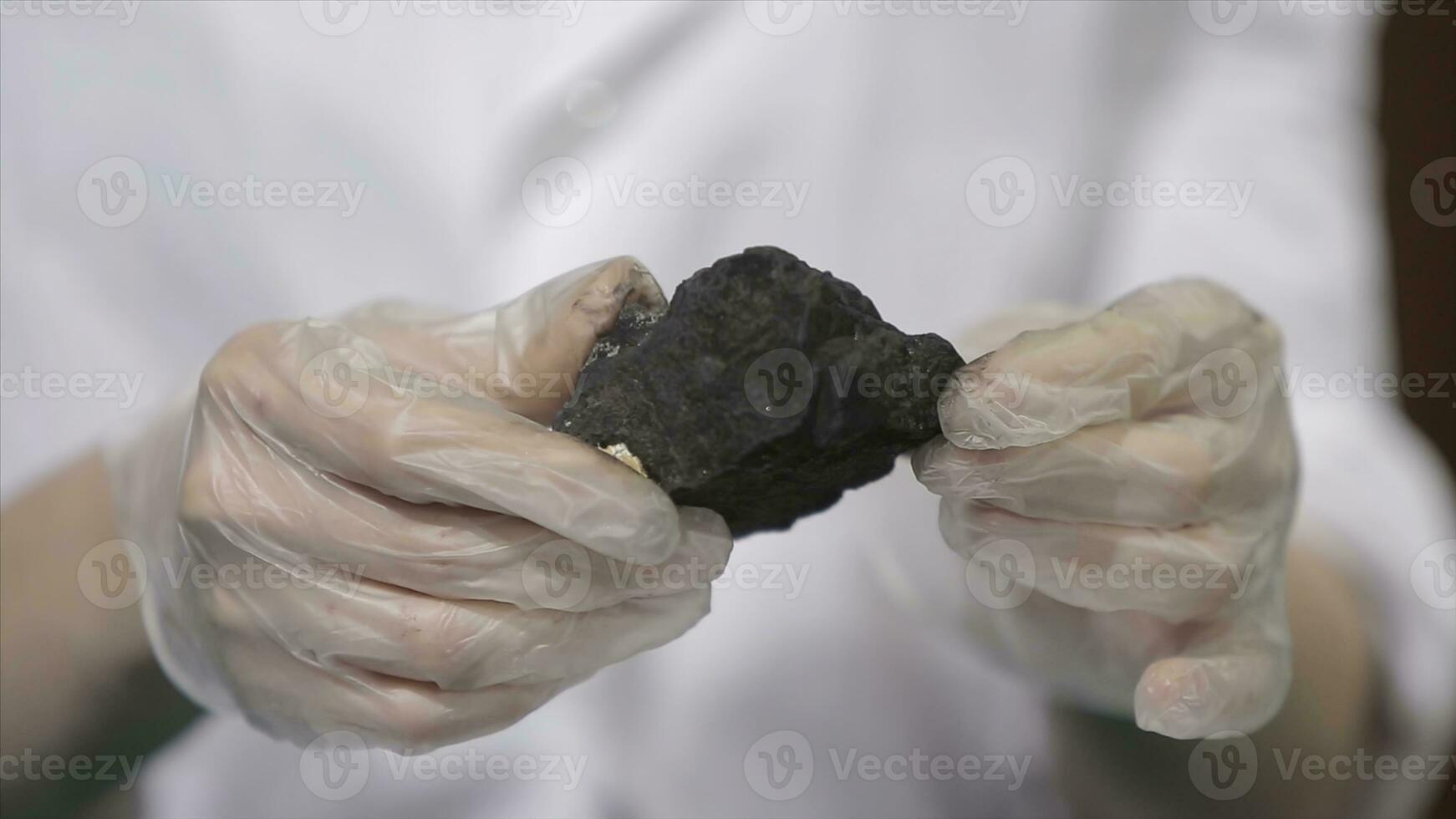 Male hands in gloves holding coal. Scientist with a sample of coal. Black coal in miner's hand photo