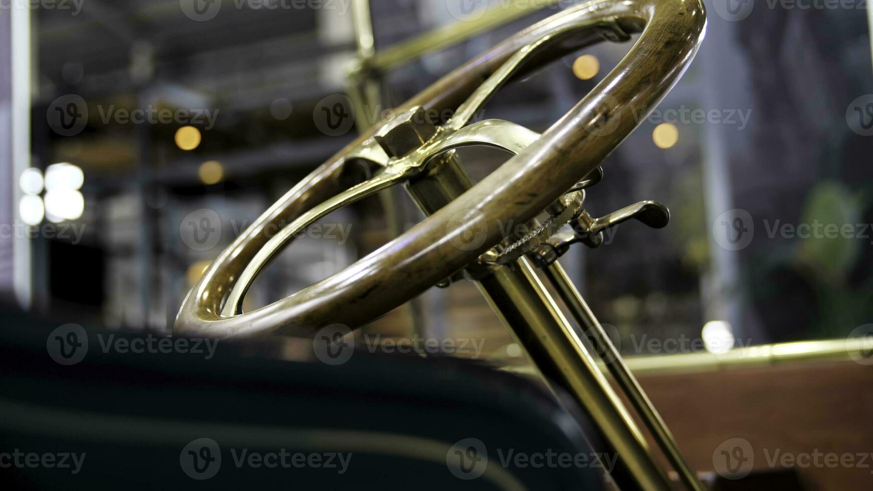 Close up of classic car details at the exhibition. Media. Retro cabriolet car and the golden steering mechanism with a wooden polished wheel. photo