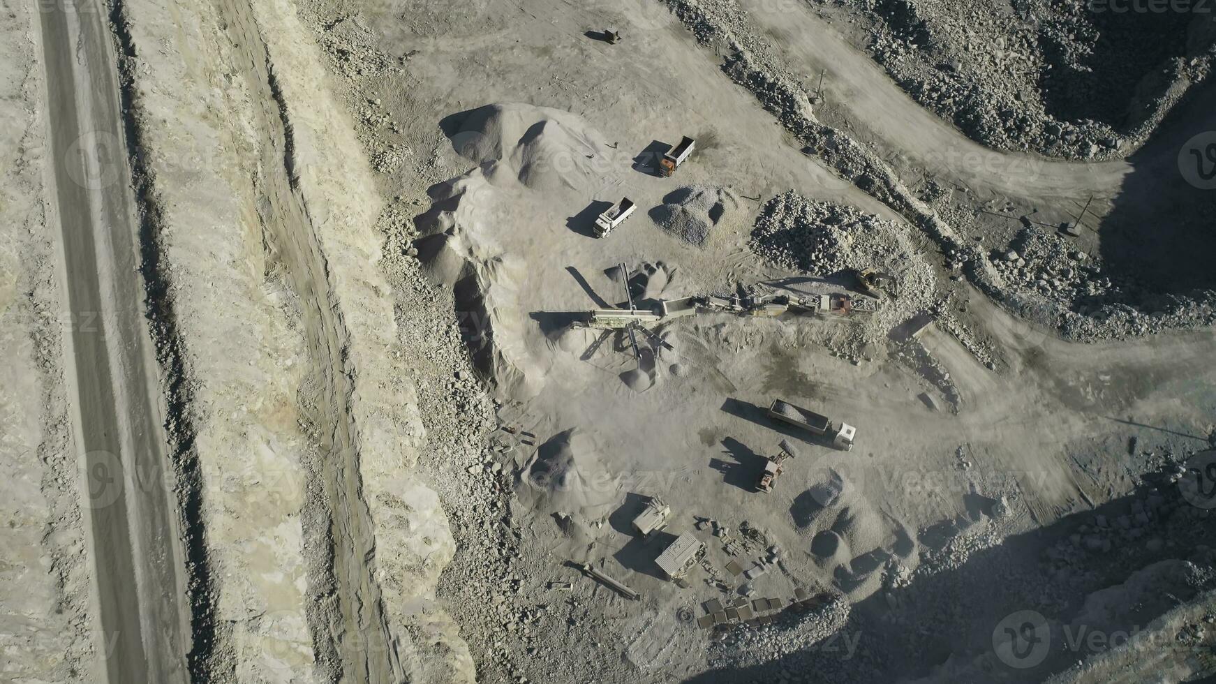 Top view of sand quarry with excavators. Shot. Open pit mining operations with operating excavators. Mining industry concept photo