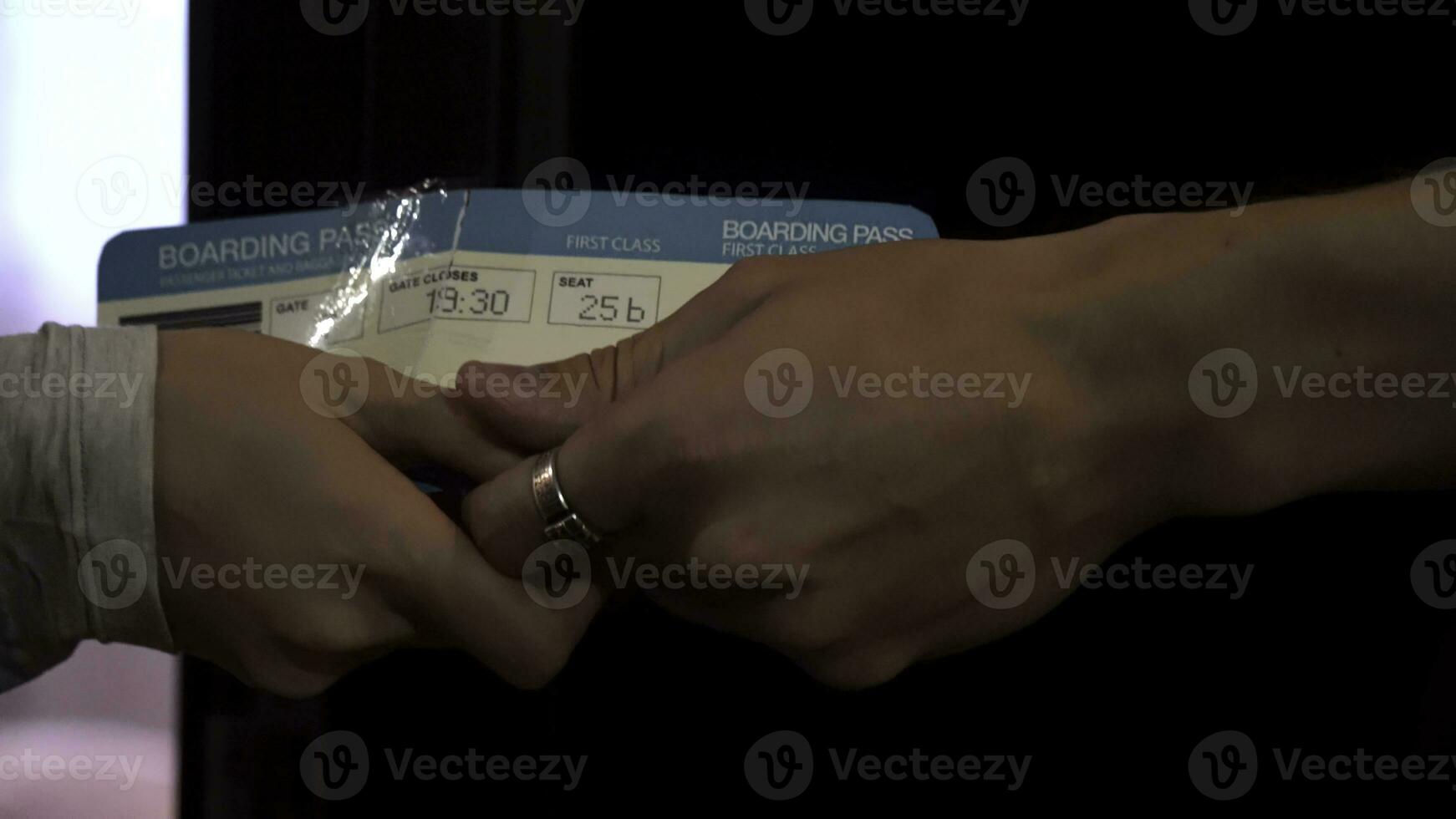 Close up for loving couple hands giving air tickets and stroking fingers. Man hands passing plane tickets to a woman hands with tenderness, side view. photo