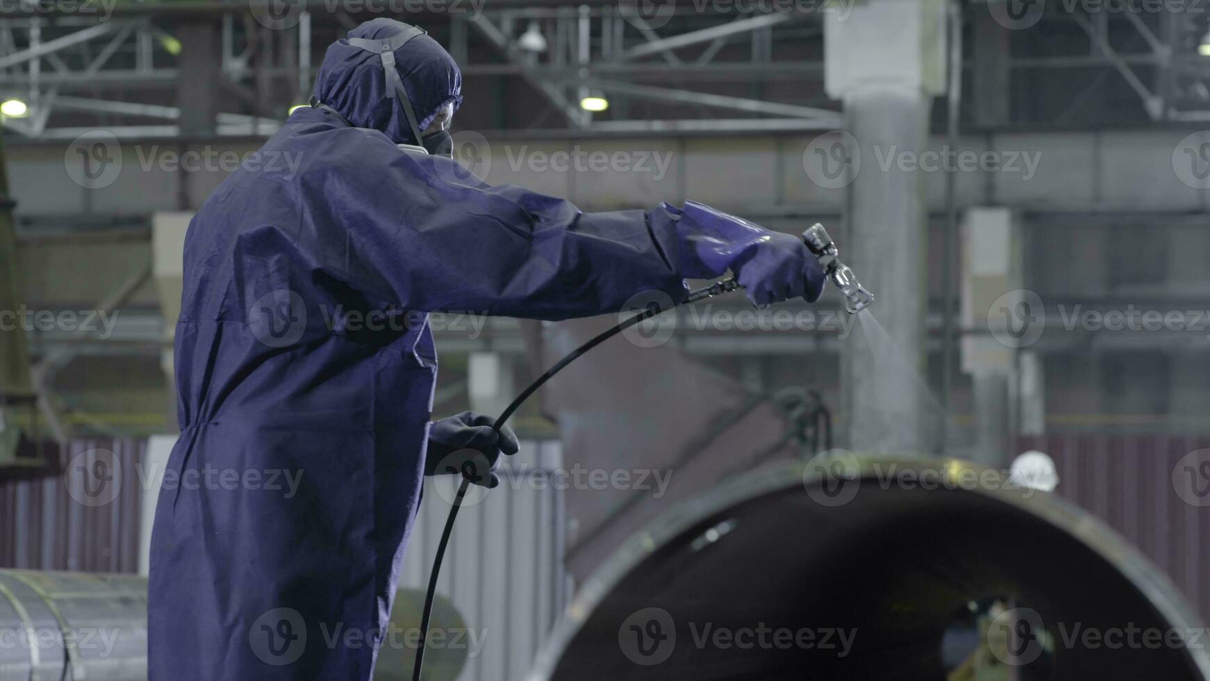 Male holding spray gun and painted steel. Man paints pipe atomizer photo