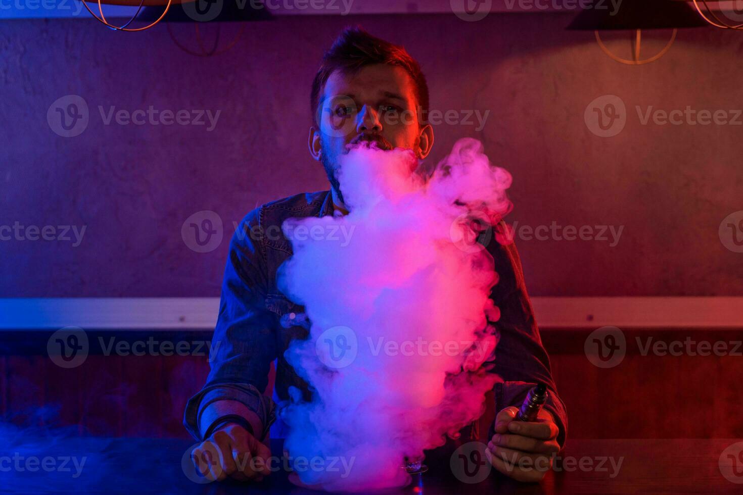 The man smoke an electronic cigarette at the vape shop. photo