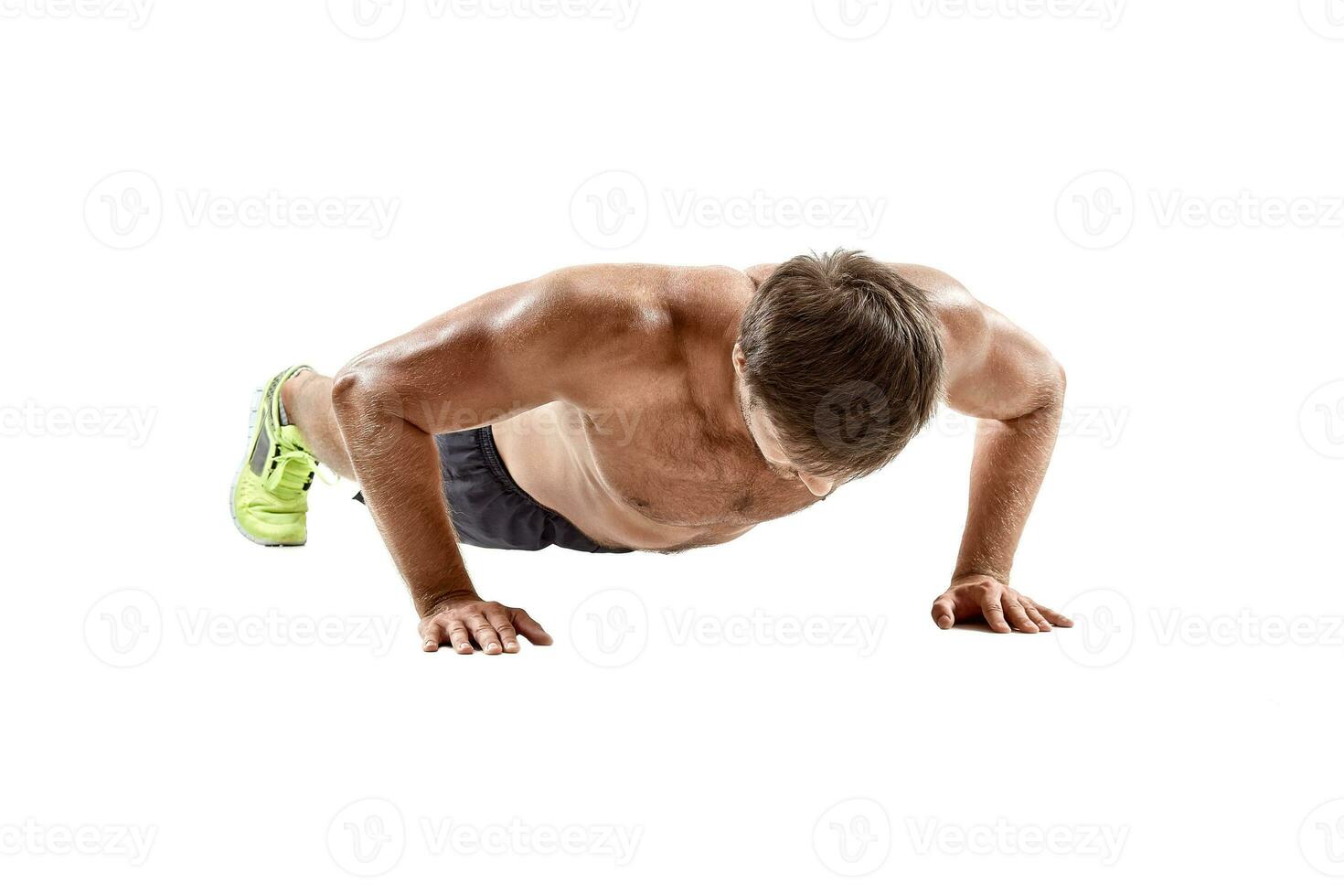 Push up fitness man doing push-up bodyweight exercise on gym floor. Athlete working out chest muscles strength training indoors photo