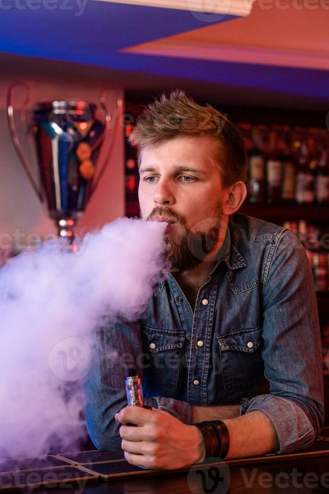 vapear vaping hombre en un nube de vapor. foto es tomado en un vape bar.