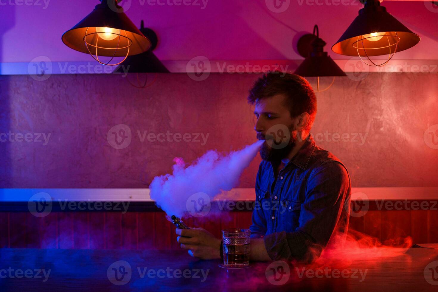 The man smoke an electronic cigarette at the vape shop. photo