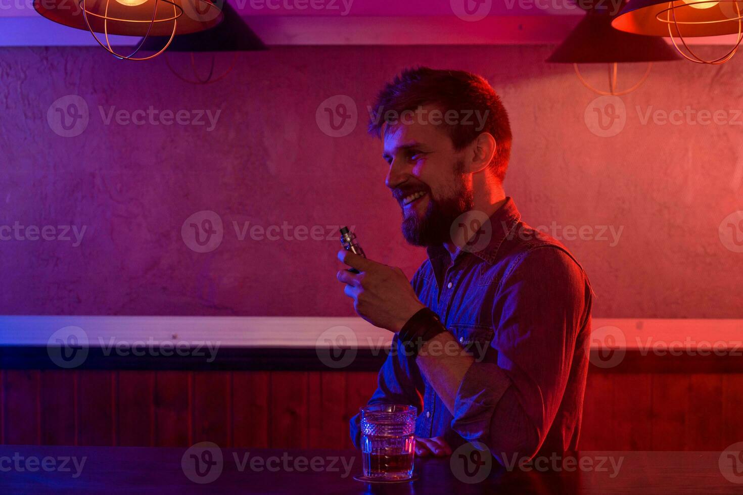 The man smoke an electronic cigarette at the vape shop. photo