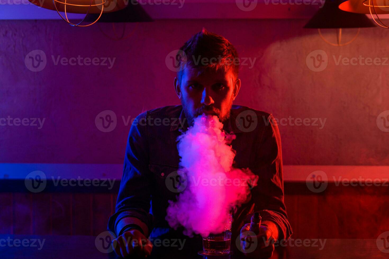 The man smoke an electronic cigarette at the vape shop. photo