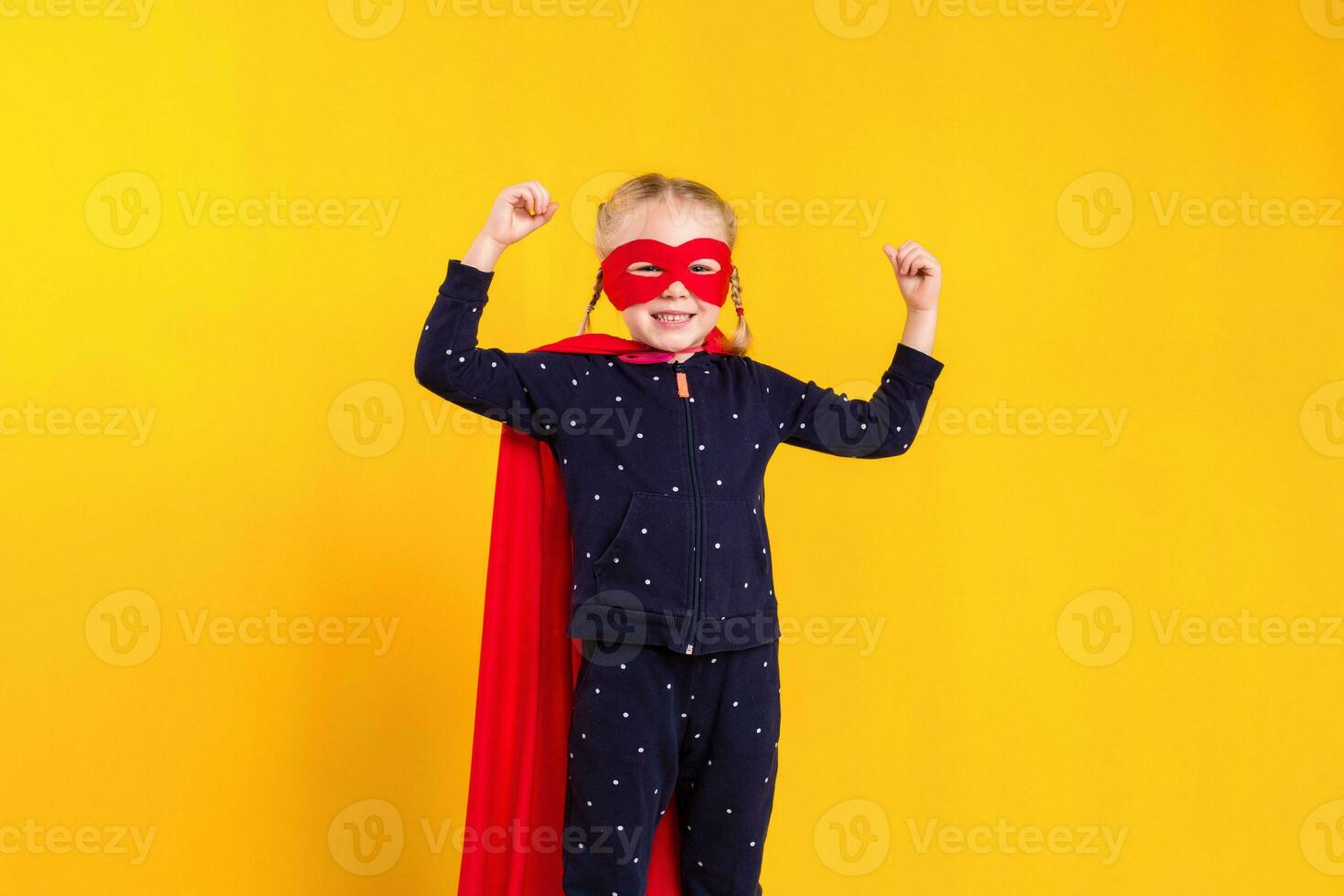 Superhero little girl in a red raincoat and a mask photo