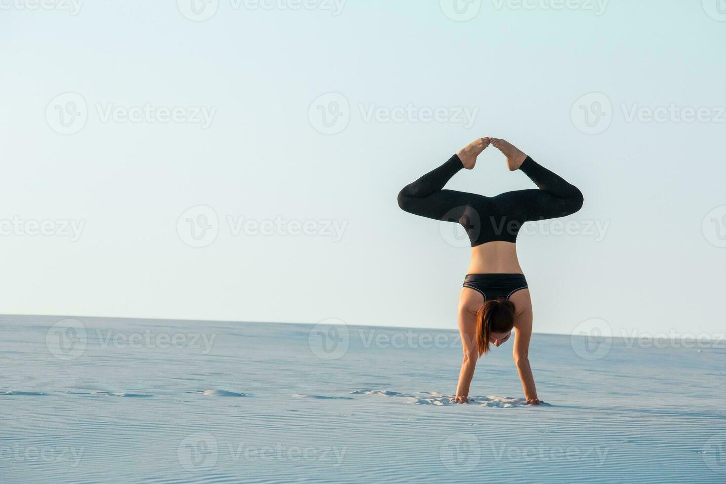 Young woman doing yoga poses at the the beach stock photo