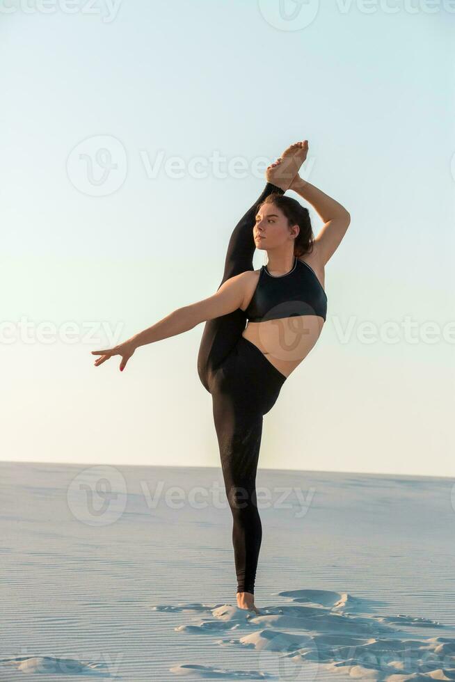 Young professional gymnast woman dance outdoor - sand beach photo