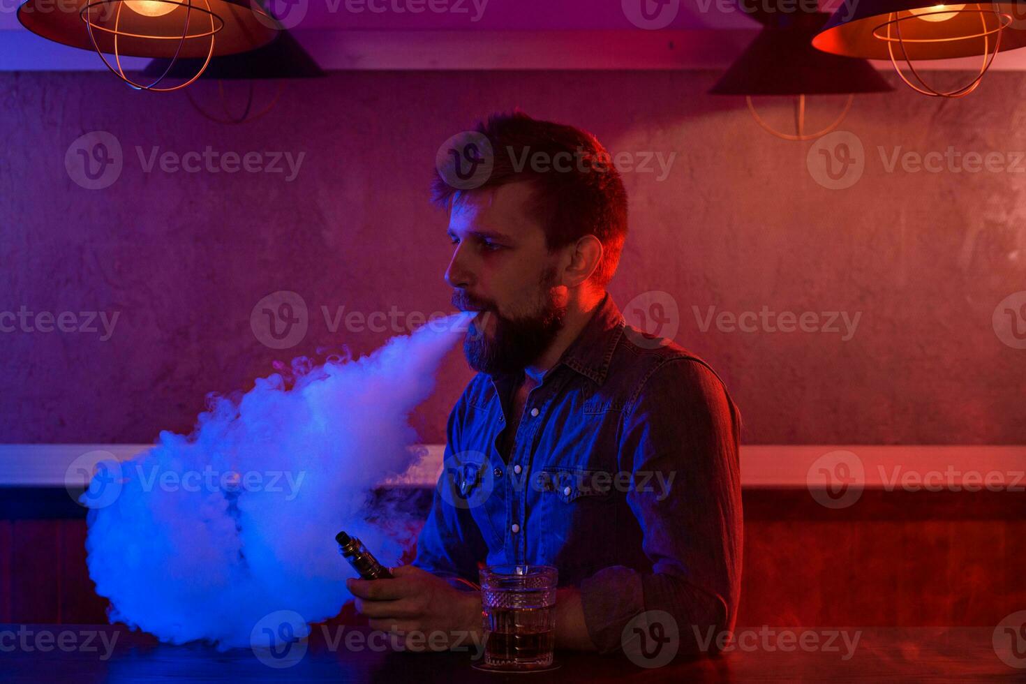 The man smoke an electronic cigarette at the vape shop. photo