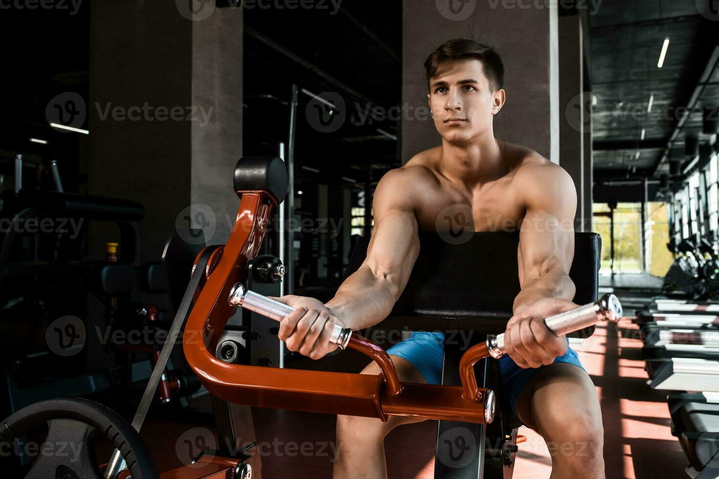 Tense muscles of hands under load. Man doing exercise for biceps in the gym. photo