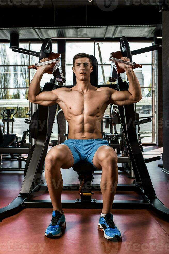 tiempo músculos de manos debajo carga. hombre haciendo ejercicio para bíceps en el gimnasia. foto